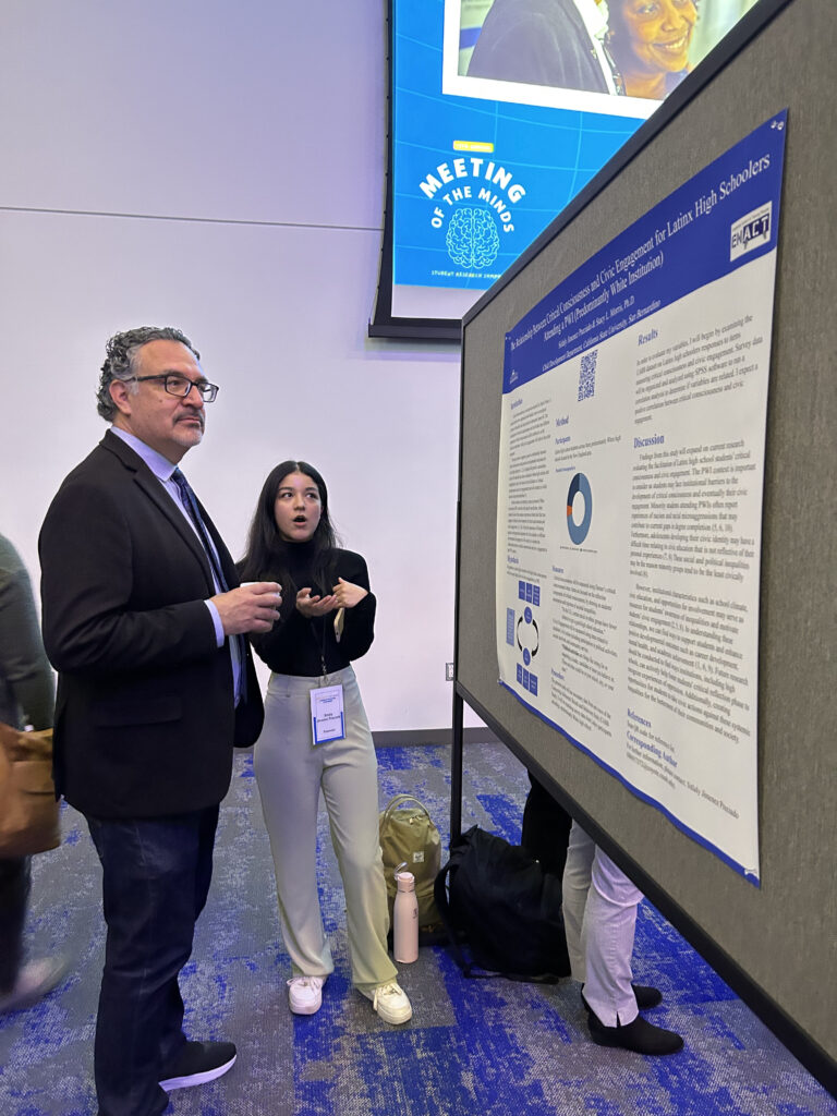 Photo of Sitlaly at Meeting of the Minds 2023, presenting her poster.